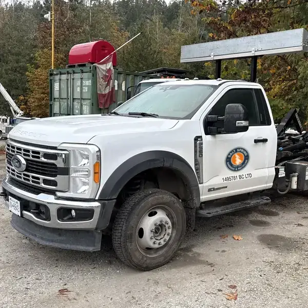 White Ford F-550 hook-lift bin truck with the Salt Spring Garbage & Recycling decal